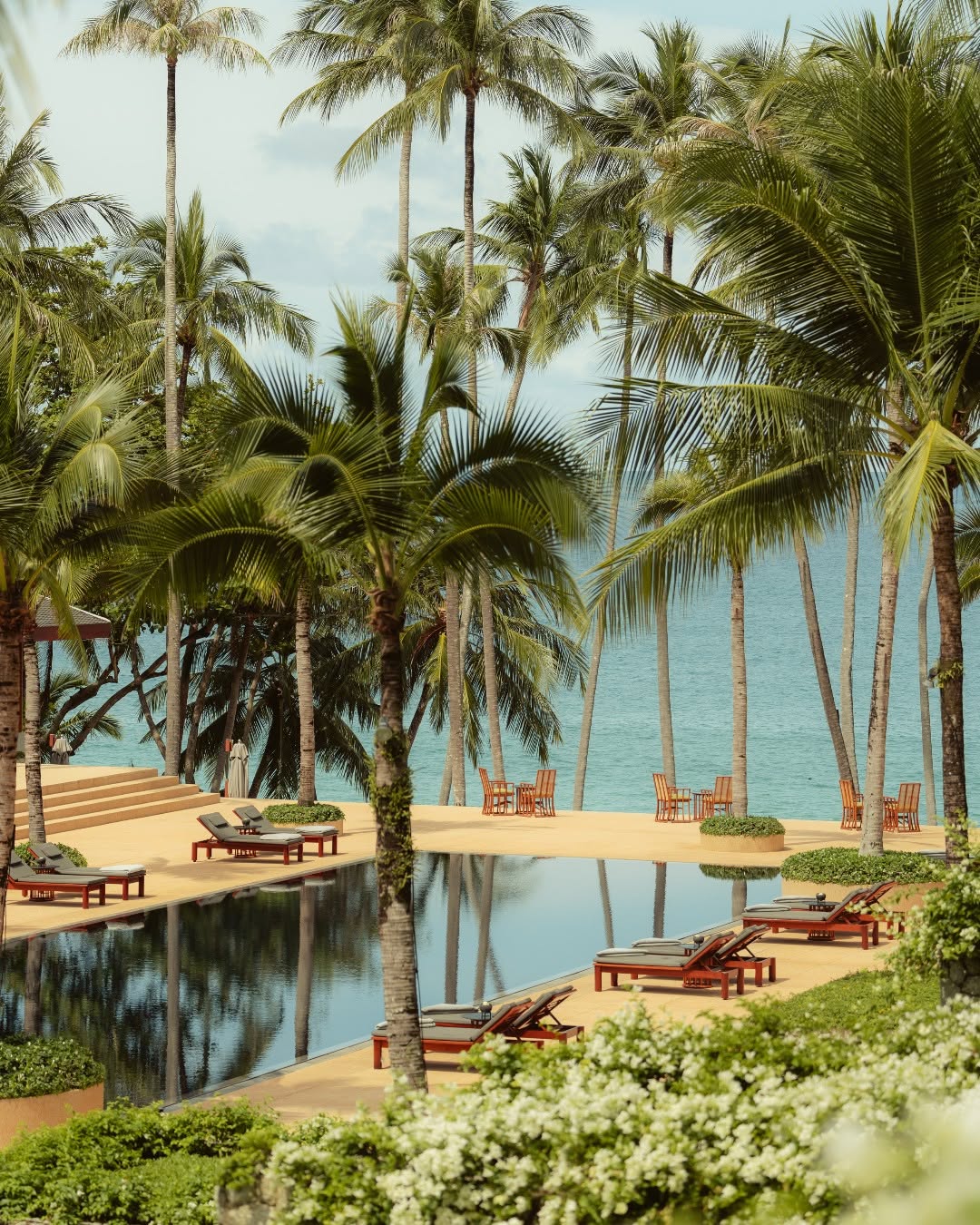 Palm-lined swimming pool at Amanpuri beside the beach
